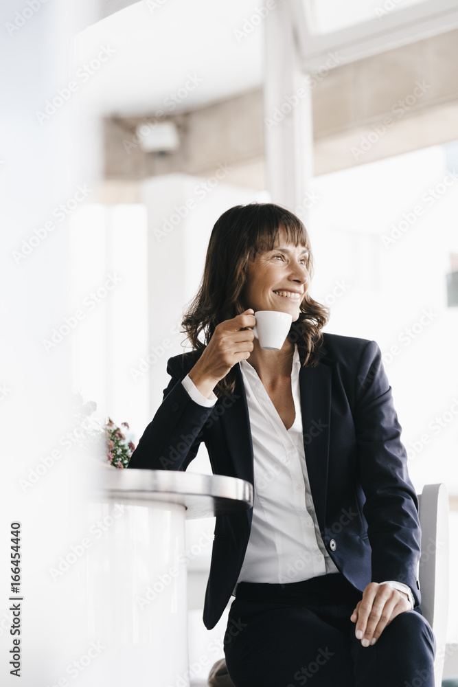 Businesswoman sitting in cafe, drinking coffee Businesswoman sitting in cafe, drinking coffee