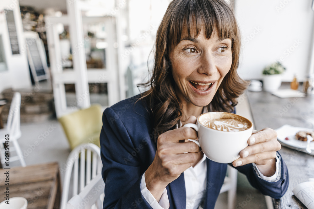Businesswoman sitting in cafe, drinking coffee Businesswoman sitting in cafe, drinking coffee