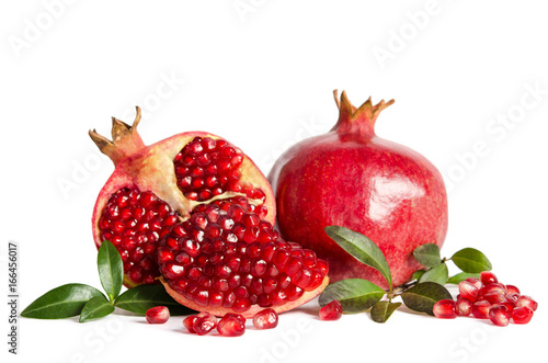whole Pomegranate and two parts of Pomegranate with leaves and seeds isolated on white