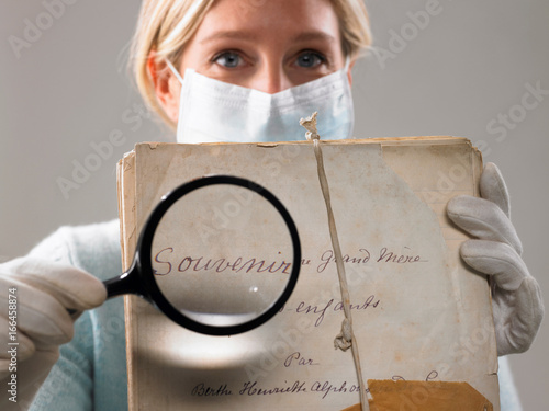 Фотография Woman with magnifying glass showing file
