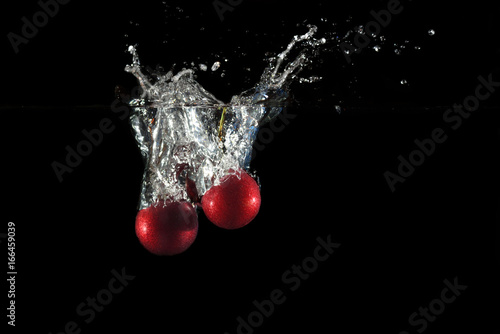 Cherries falling into water with splash