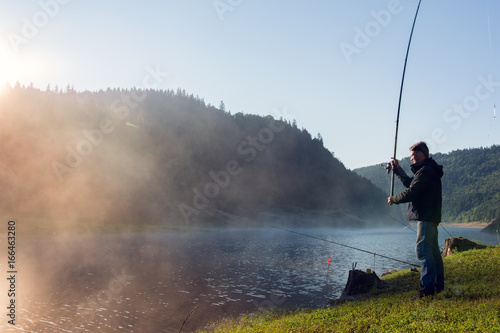 Man fishing for pleasure in the light of sunrise