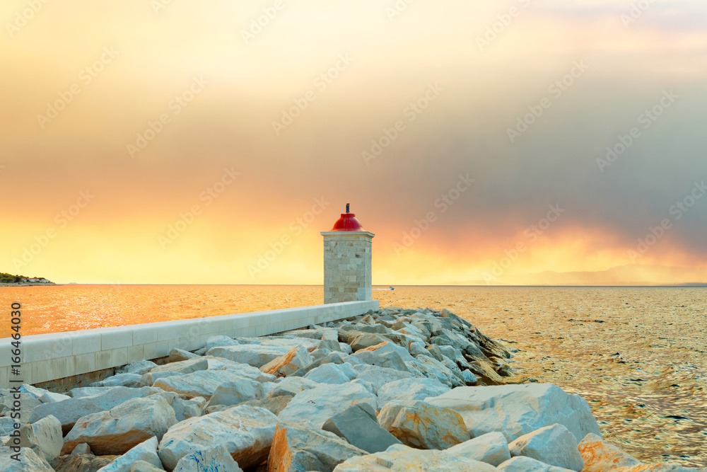 Fototapeta premium Lighthouse in the harbor of a small town called Postira shot at sunset - Croatia, island Brac