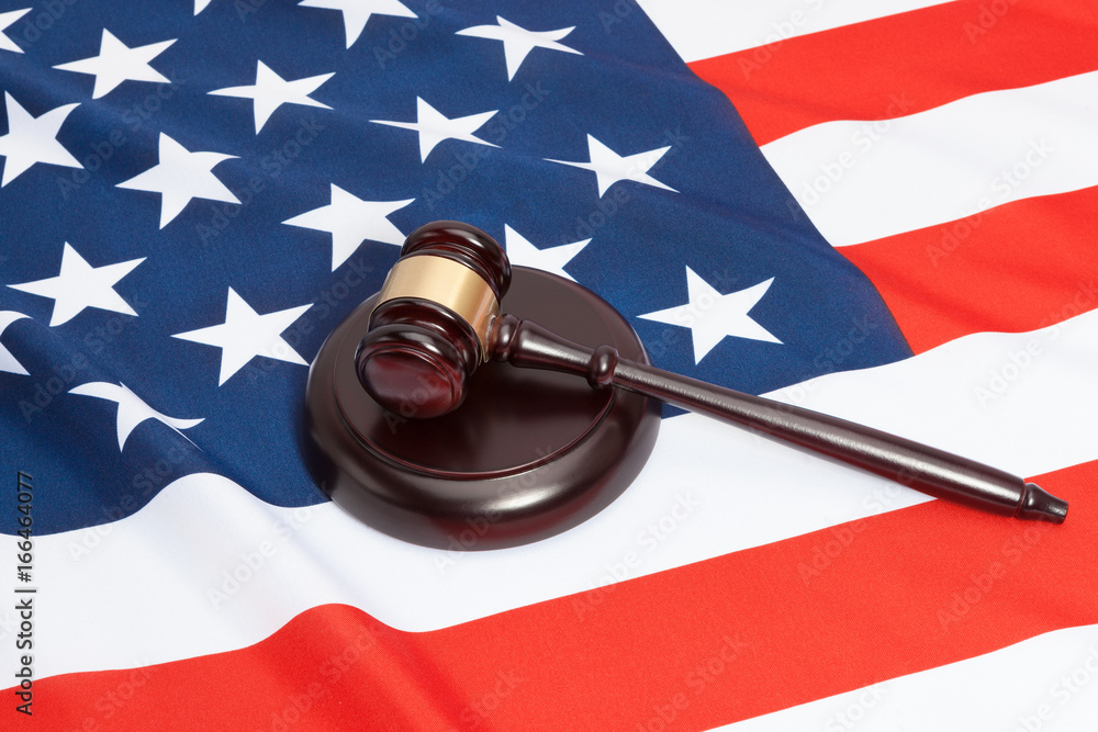 Close up studio shot of a judge gavel and soundboard laying over USA flag