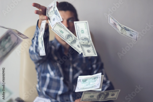 a young man throws money (dollars) photo