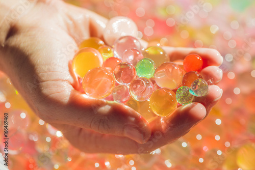 Colored balls of water beads, hydrogel in in hands. Sensory experiences photo