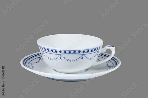 weiße teetasse mit blauem dekor auf grauem hintergrund