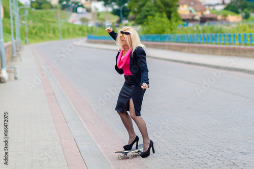 Senior business woman having fun on a skateboard outdoors. The concept of moving forward.