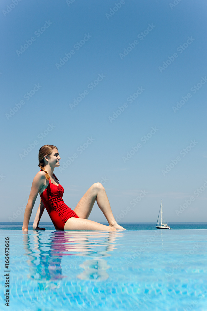 Young woman by swimming pool, portrait