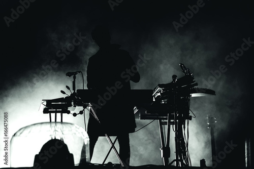 Silhouette of a keyboardist in stage lights photo