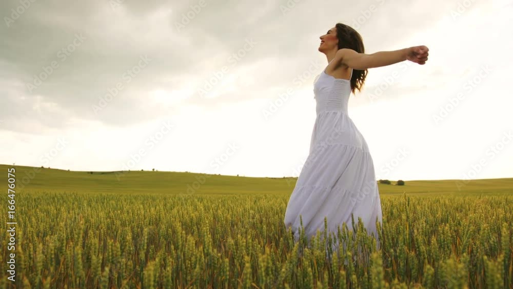 Young emotional woman in the white dress spinning in wheat field. Young emotional woman in the white dress spinning in wheat field.