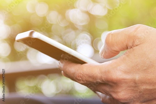 A man using smartphone in the garden Outdoor working concept.