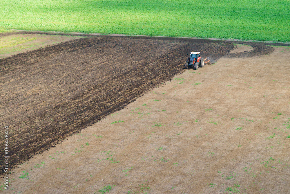 Obraz premium Tractor plowing field
