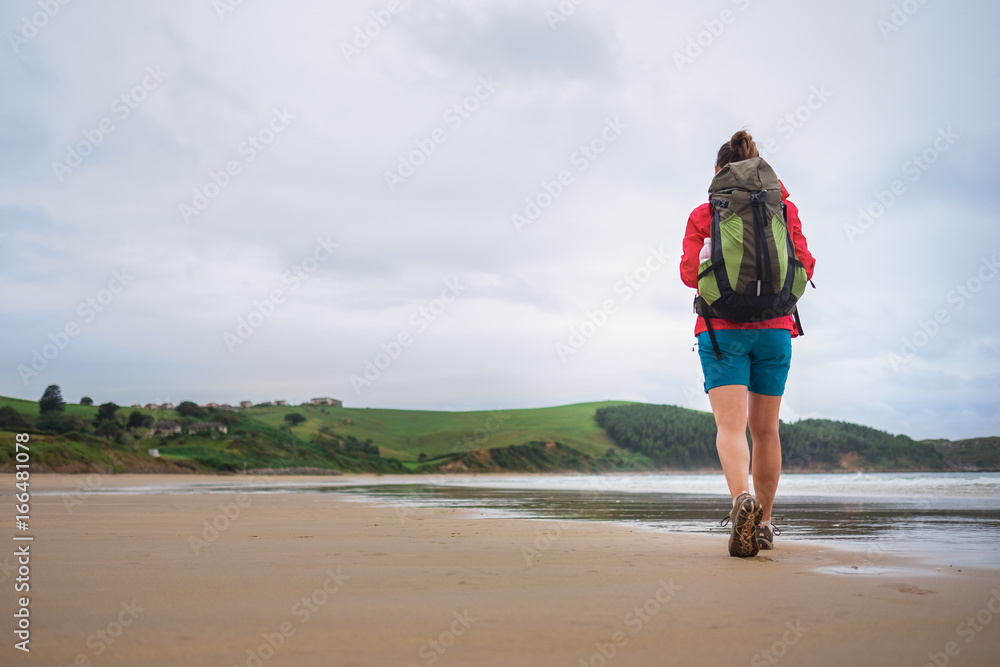 Backpacker girl traveler walk on deserted ocen beach Backpacker girl traveler walk on deserted ocen beach