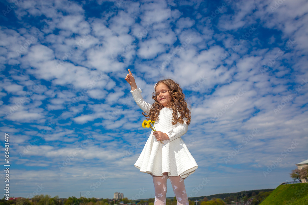 little girl in the clouds. little girl walks among the clouds. dreamy and fantasy concept. Little girl shows up. The girl looks up in surprise little girl in the clouds. little girl walks among the clouds. dreamy and fantasy concept. Little girl shows up. The girl looks up in surprise