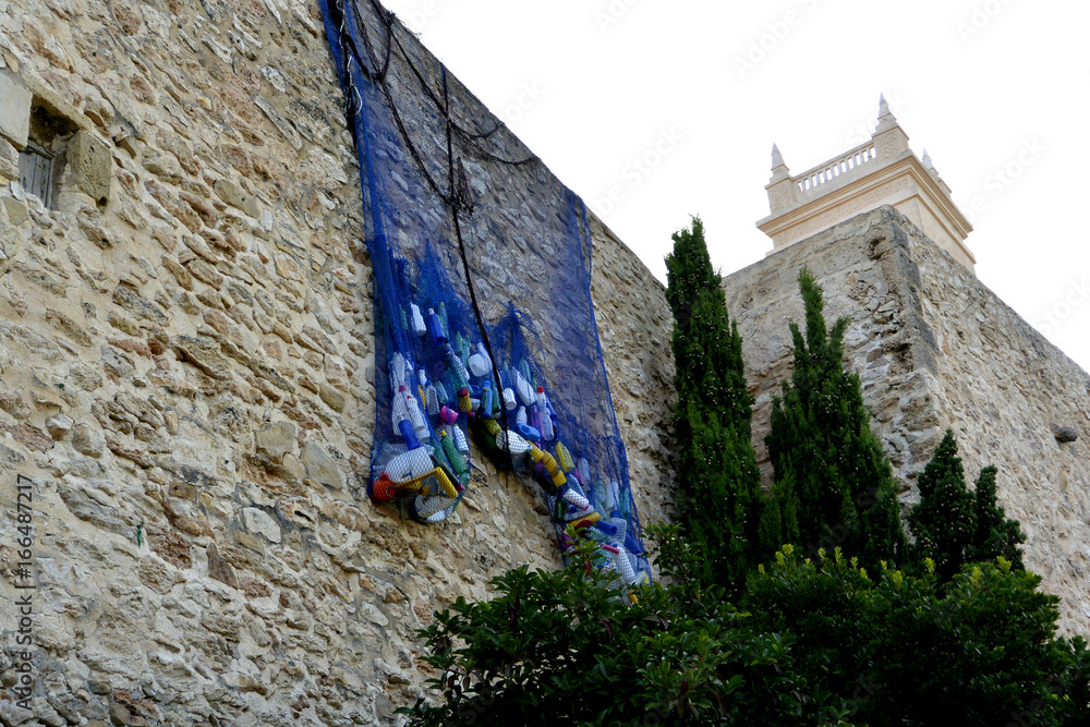 Botellas de plastico que dejamos en el mar estan en la red colgando en  pared en casco antiguo de Calpe, España foto de Stock | Adobe Stock