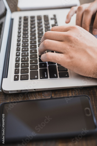 Morning business men.muzhskie hands working on a laptop, next to the phone. Horizontal frame