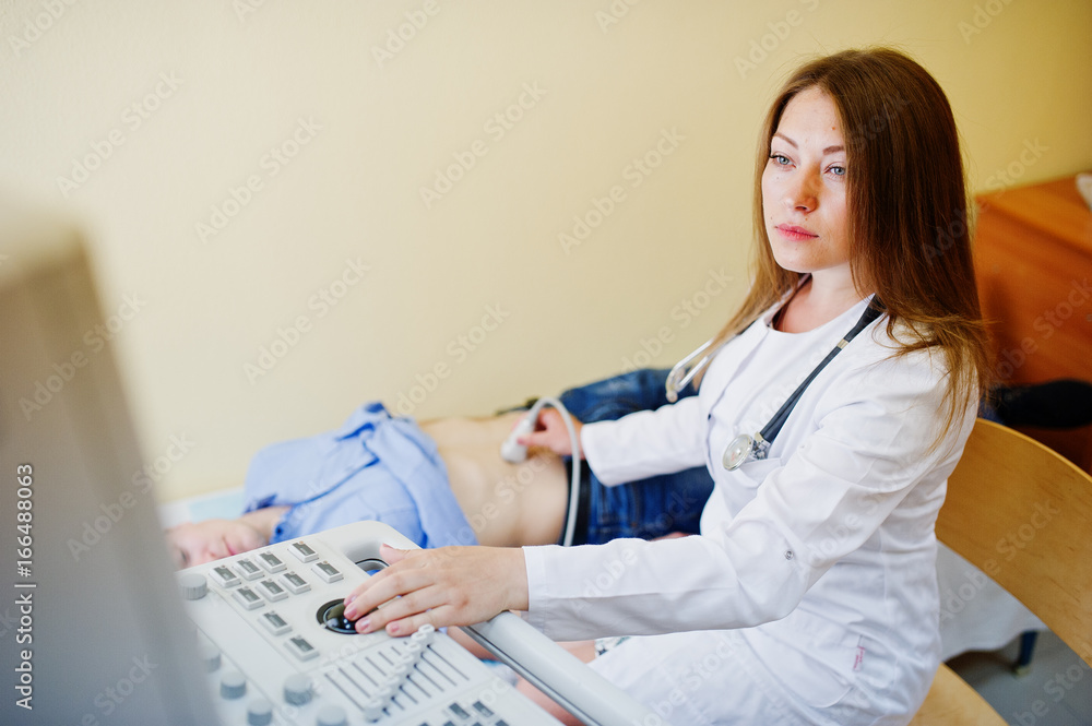 Beautiful young doctor doing diagnostic sonography on a patient. Beautiful young doctor doing diagnostic sonography on a patient.