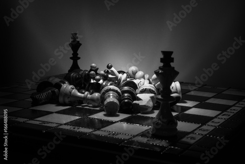 Black and white chess setup of king's shapes, and different pieces with dramatic lighting photo