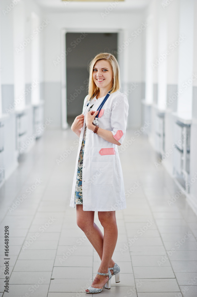 Portrait of a young attractive doctor in white coat with stethoscope posing in the hospital. Portrait of a young attractive doctor in white coat with stethoscope posing in the hospital.