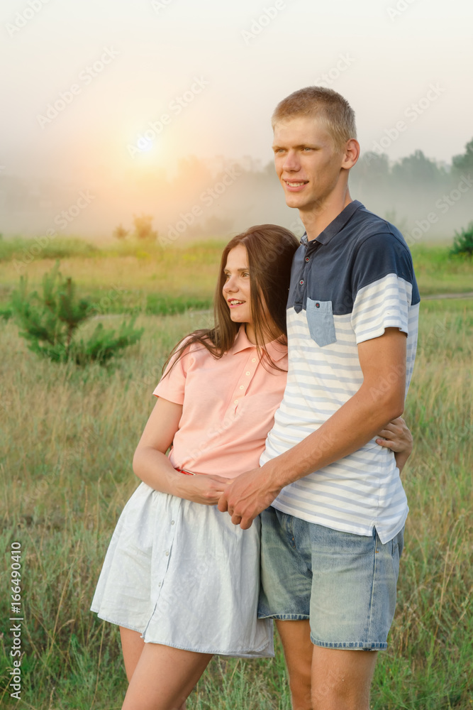 Young romantic loving couple stands in the middle of the field Young romantic loving couple stands in the middle of the field