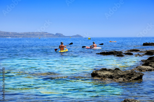 Mężczyźni w kajakach u brzegu wyspy Rodos w Grecji, spływ kajakowy.