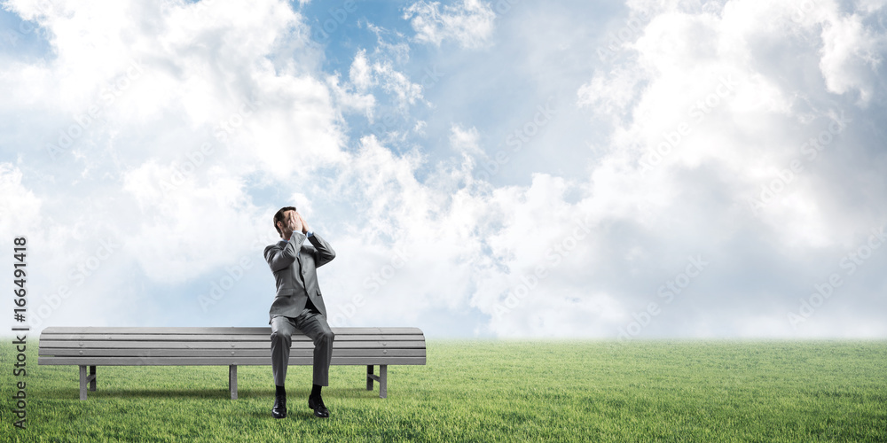 Young man in summer park on bench do not want to see anything Young man in summer park on bench do not want to see anything