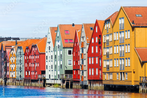 Famous wooden colored houses in Trondheim city, Norway. Colorful houses on stilts in sunny day. photo