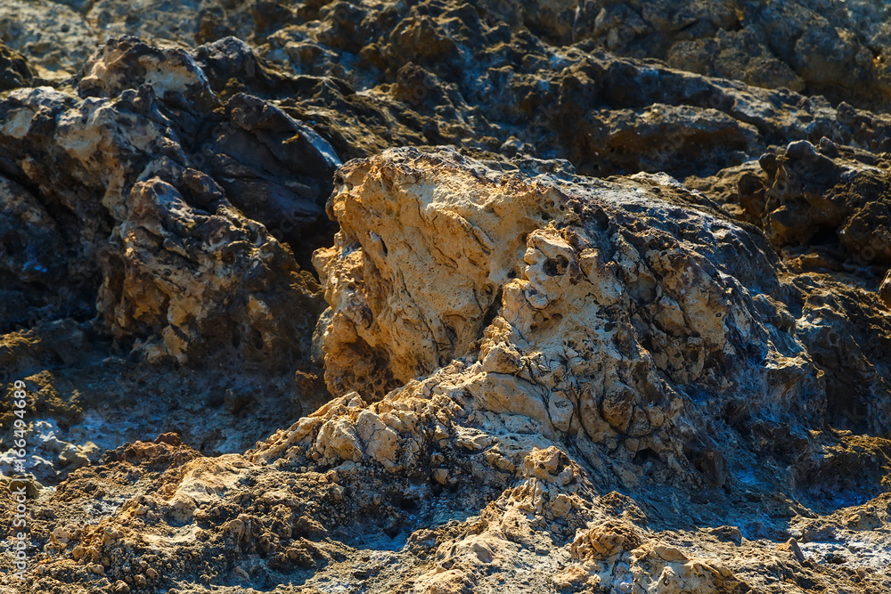 Volcanic stone formations on beach. Natural texture with blur