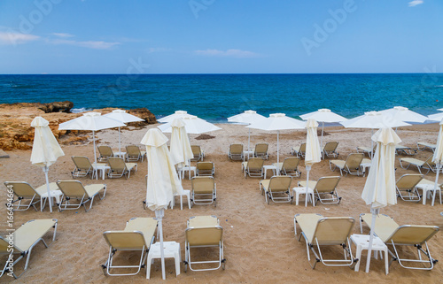 Sandy beach with parasols and beach loungers Crete