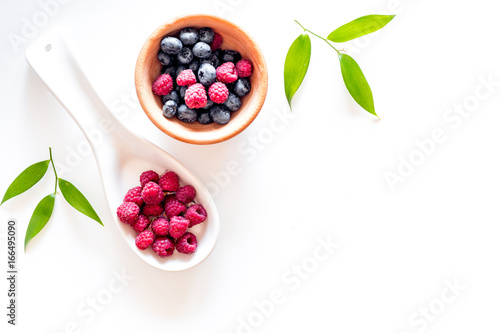 Paspberry and blueberry for preparing jam on white background top view copyspace