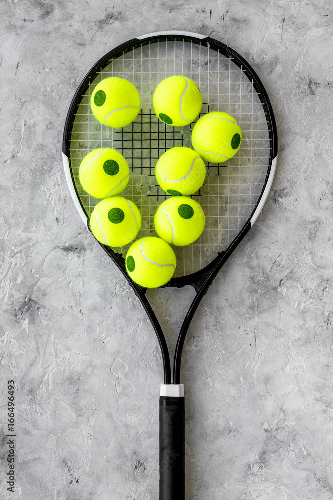 Sport background. Tennis balls and racket on grey background top view
