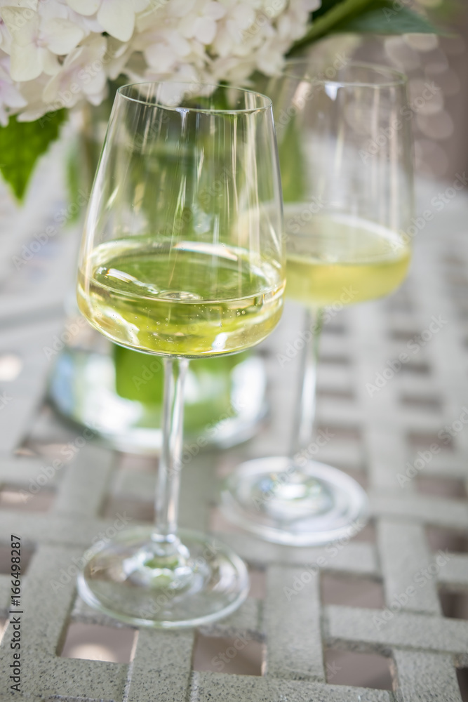 Two Glasses of White Wine on a Garden Table Outdoors Two Glasses of White Wine on a Garden Table Outdoors