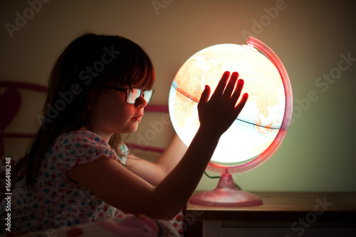 Side view of a girl holding illuminated globe