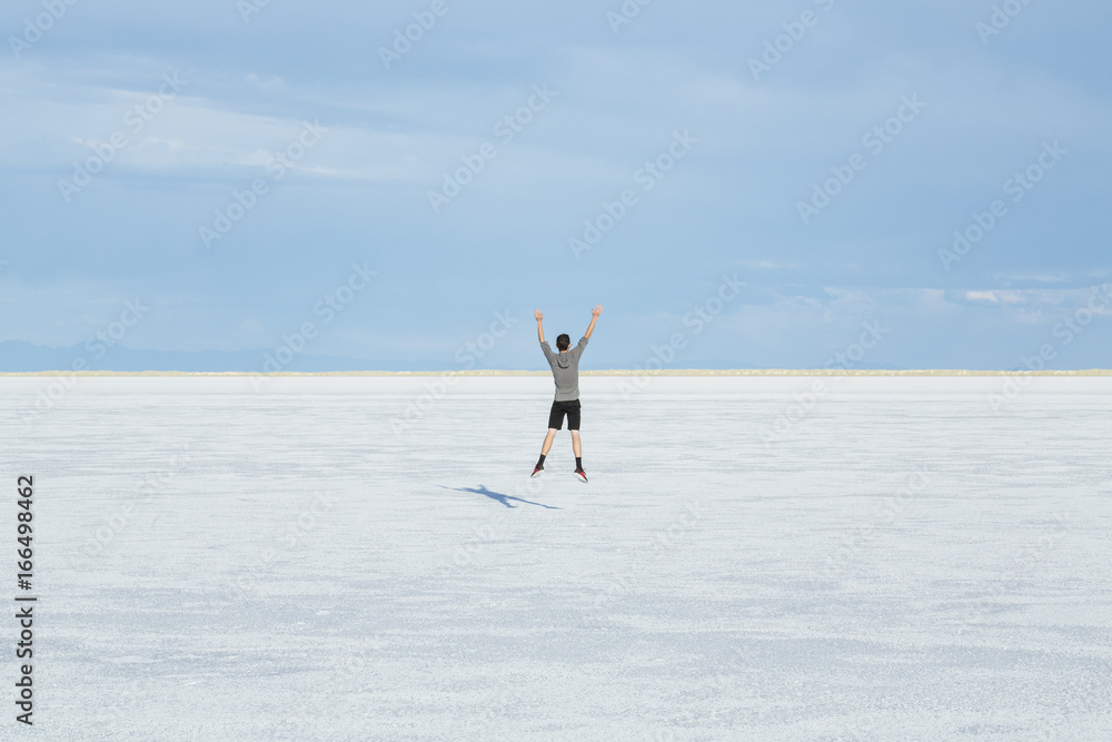 Teenage boy jumping in the air on the vast salt flats of Utah Teenage boy jumping in the air on the vast salt flats of Utah