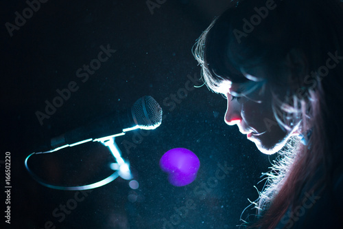 Beautiful woman rock pop star singer performer performing music with microphone