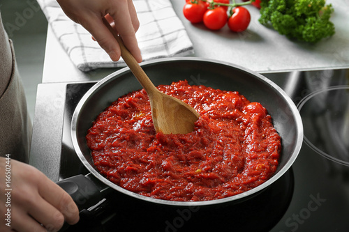 Φωτογραφία Woman preparing tomato sauce in frying pan