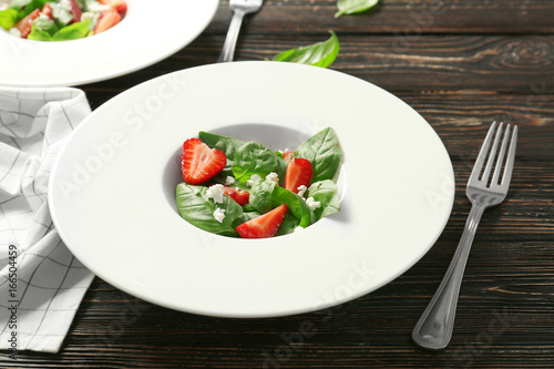Tasty salad with spinach and strawberry on plate