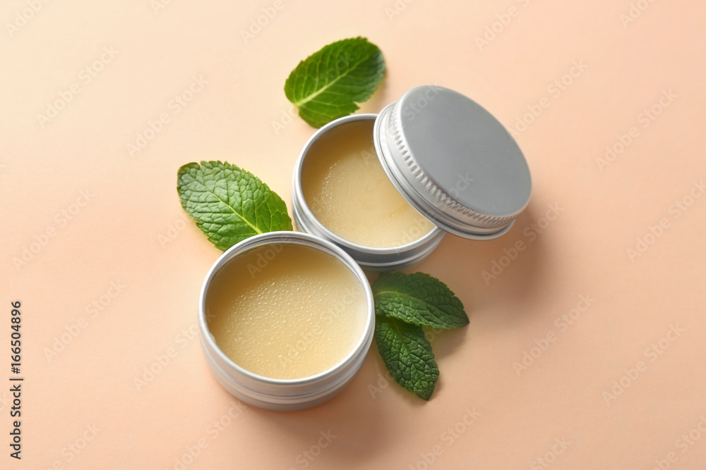 Containers with lemon balm salve and leaves on  light background - obrazy, fototapety, plakaty 