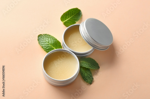 Containers with lemon balm salve and leaves on  light background photo