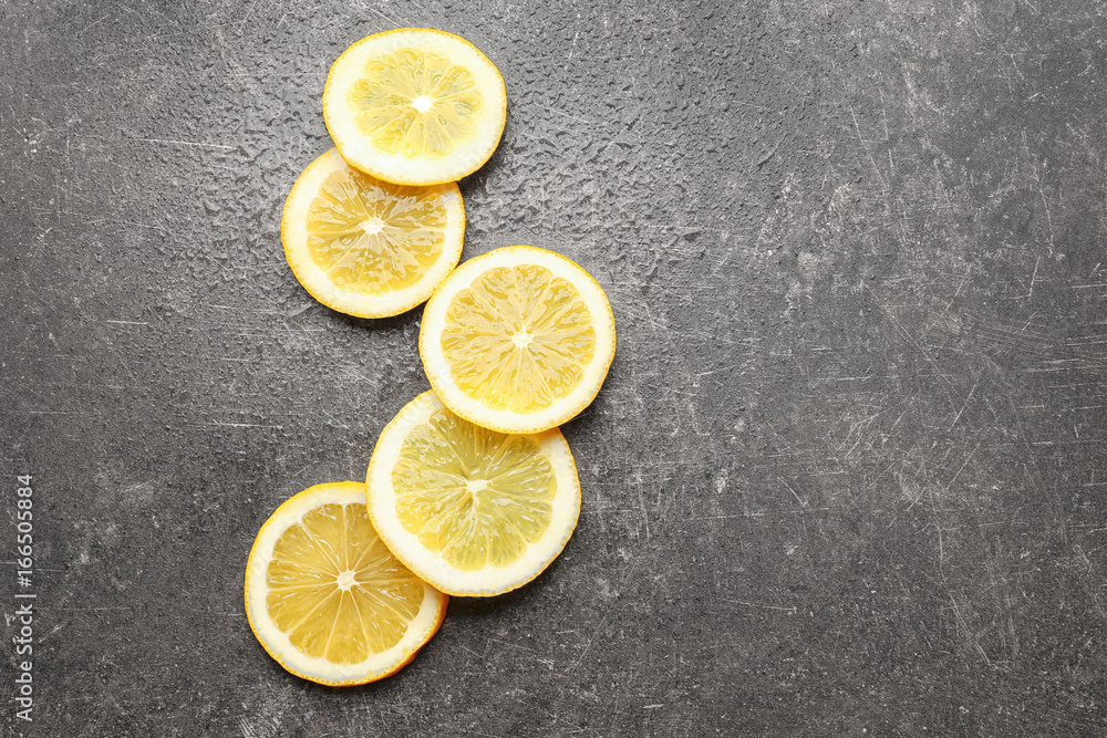 Delicious sliced citrus fruit and green leaves on grey background Delicious sliced citrus fruit and green leaves on grey background