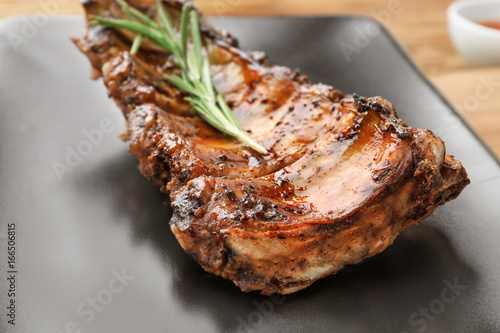 Plate with delicious pork ribs and rosemary, closeup