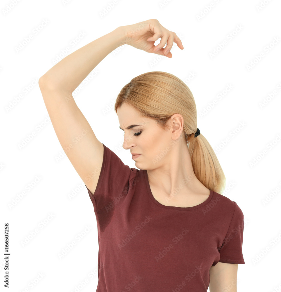 Young woman with sweat stain on her t-shirt against white background. Concept of using deodorant Young woman with sweat stain on her t-shirt against white background. Concept of using deodorant