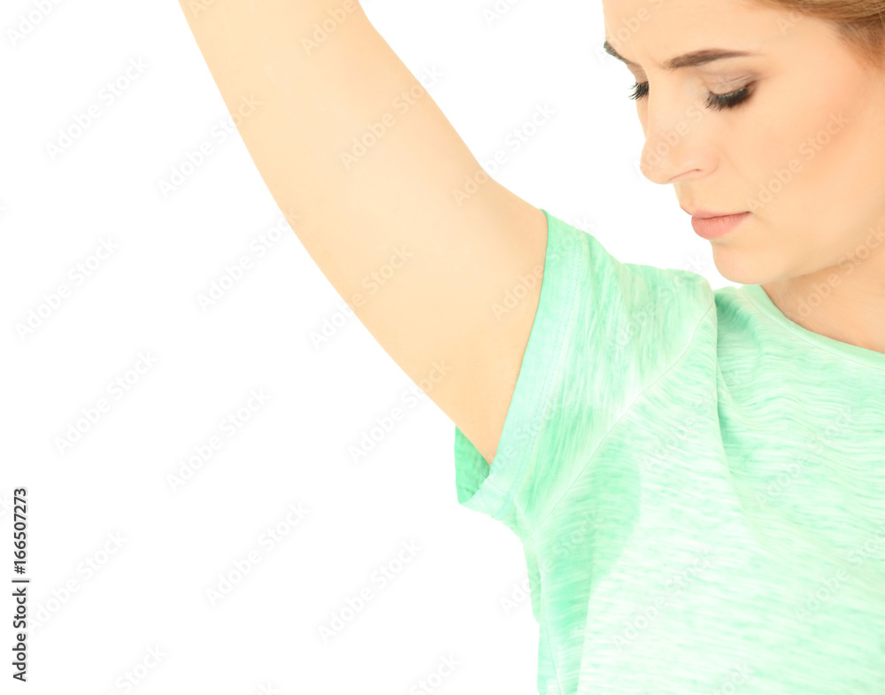 Young woman with sweat stain on her t-shirt against white background. Concept of using deodorant Young woman with sweat stain on her t-shirt against white background. Concept of using deodorant