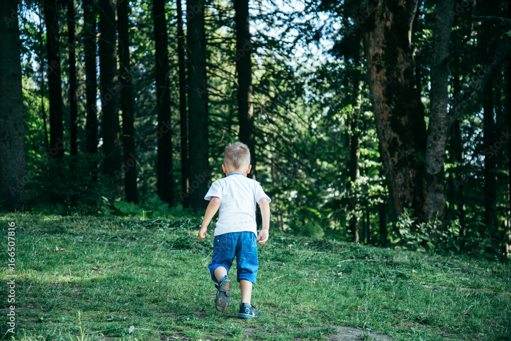 Little boy in national clothes running in the forest Little boy in national clothes running in the forest