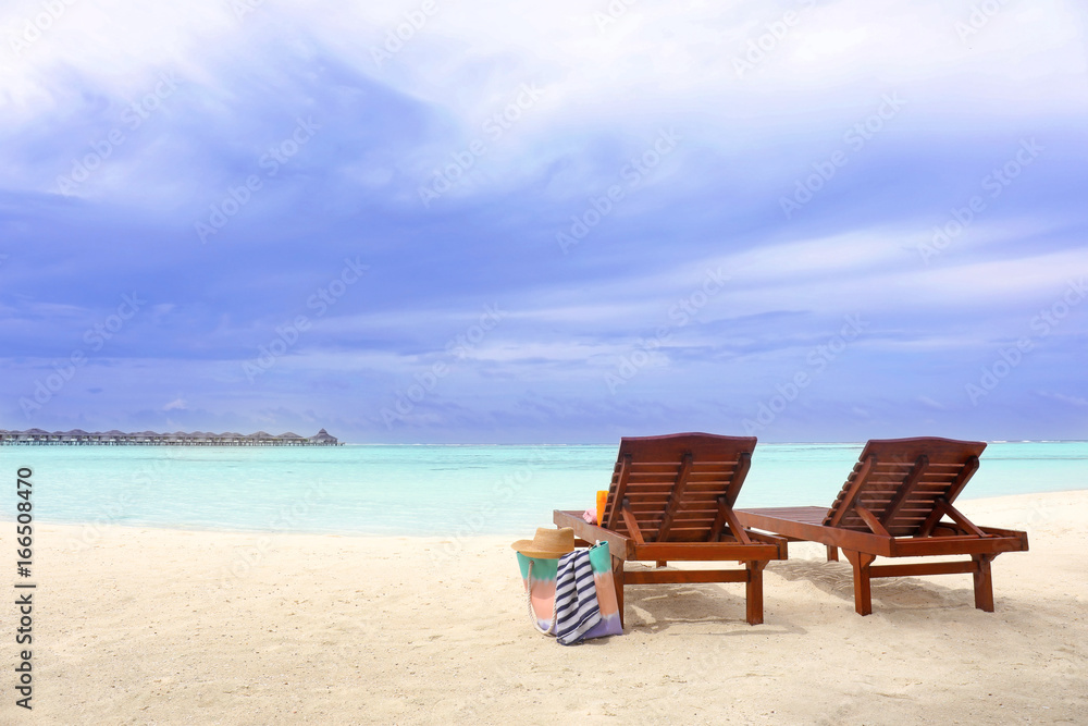 Fototapeta premium Drewniane leżaki z akcesoriami plażowymi w nadmorskim kurorcie