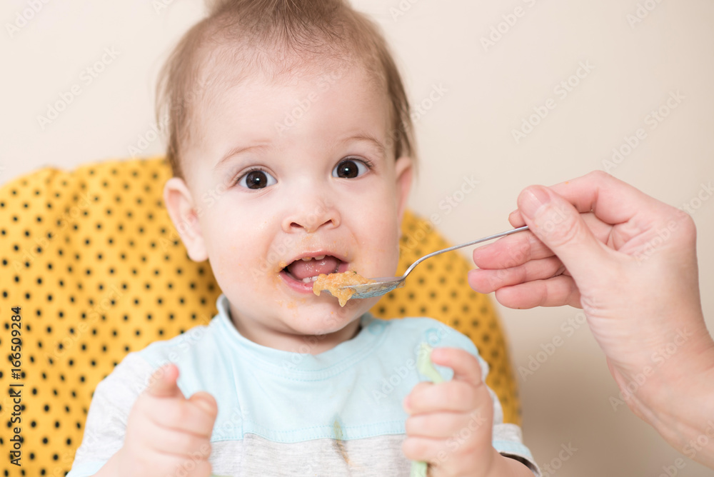 grandmother gives baby food from a spoon grandmother gives baby food from a spoon