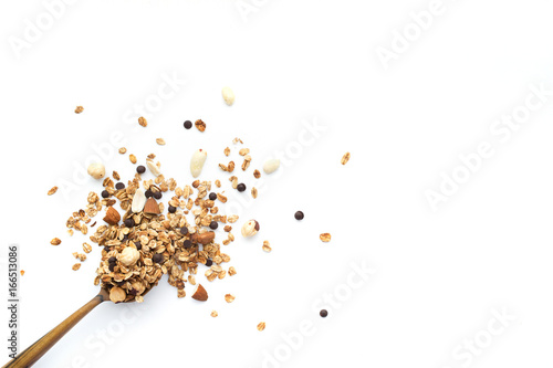 Crumbled granola in a wooden spoon isolated on a white background.  Top view. photo