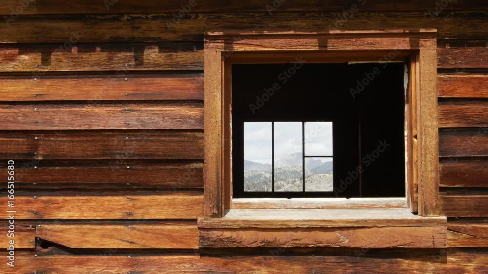 A window peers through a small wooden cabin. A window peers through a small wooden cabin.