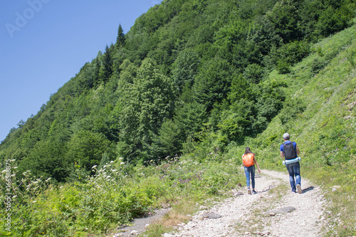 Active and healthy lifestyle on summer vacation and weekend tour. Group of tourists hitching a ride. Travel adventure and hiking activity